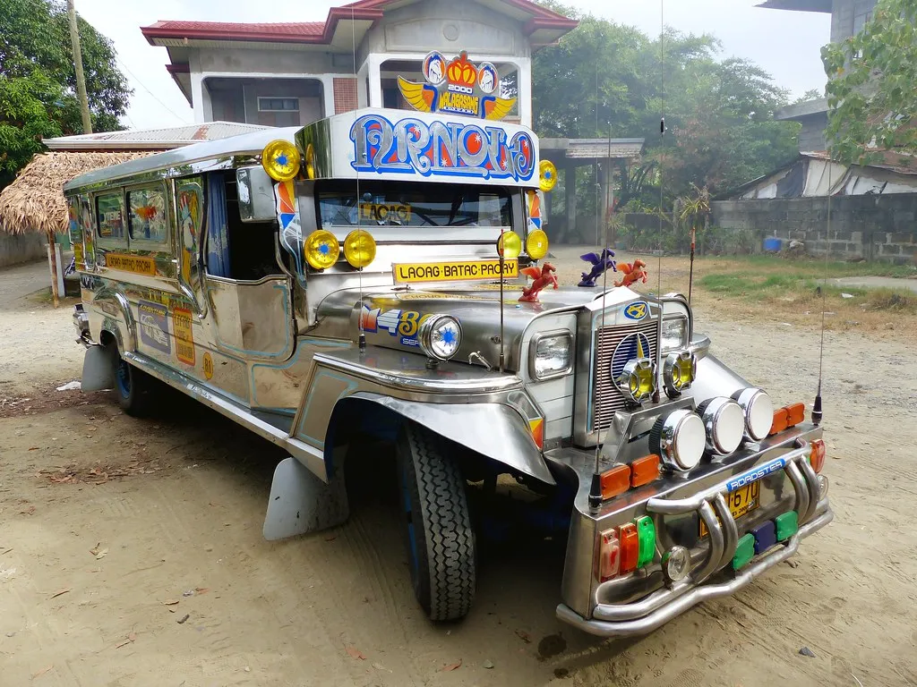 Chrome-covered jeepney parked outside houses